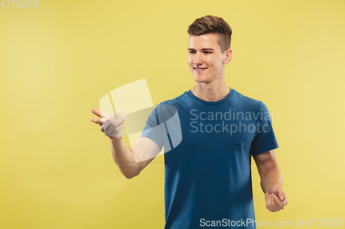 Image of Caucasian young man\'s half-length portrait on yellow background