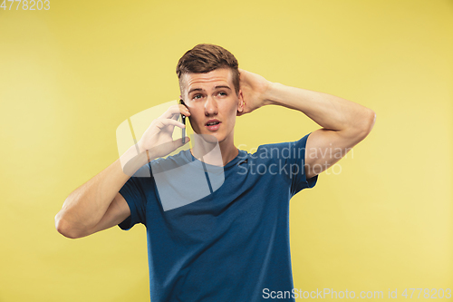 Image of Caucasian young man\'s half-length portrait on yellow background