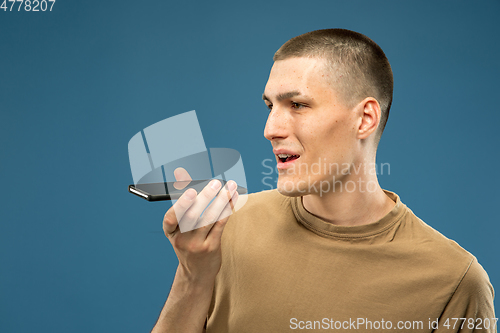 Image of Caucasian young man\'s half-length portrait on blue background