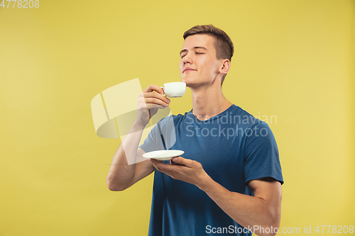 Image of Caucasian young man\'s half-length portrait on yellow background