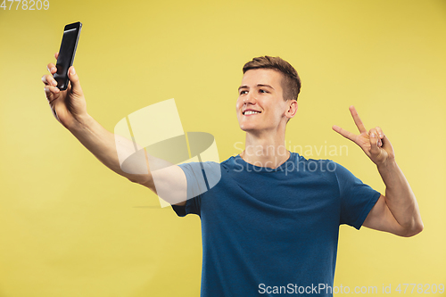 Image of Caucasian young man\'s half-length portrait on yellow background