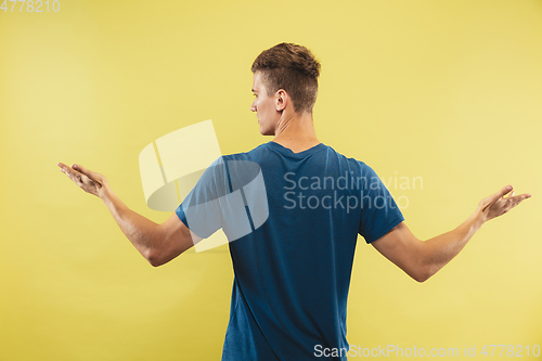 Image of Caucasian young man\'s half-length portrait on yellow background