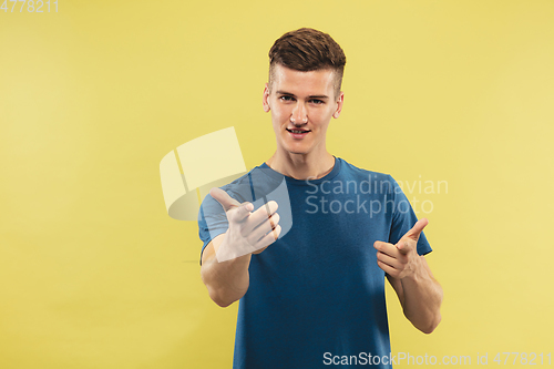 Image of Caucasian young man\'s half-length portrait on yellow background