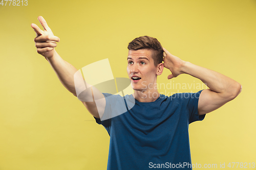 Image of Caucasian young man\'s half-length portrait on yellow background