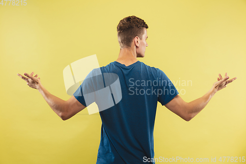 Image of Caucasian young man\'s half-length portrait on yellow background