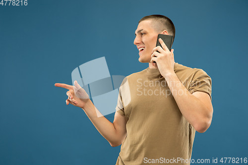 Image of Caucasian young man\'s half-length portrait on blue background