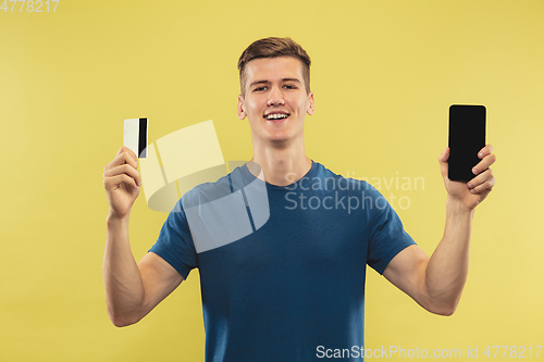 Image of Caucasian young man\'s half-length portrait on yellow background