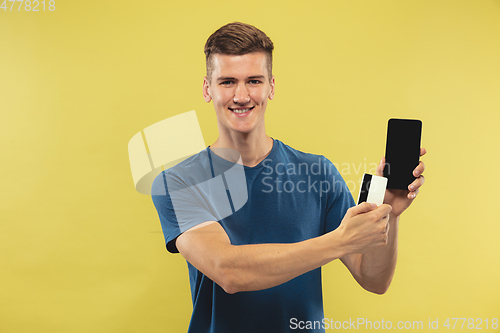 Image of Caucasian young man\'s half-length portrait on yellow background