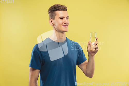 Image of Caucasian young man\'s half-length portrait on yellow background