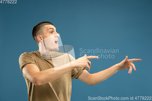 Image of Caucasian young man\'s half-length portrait on blue background