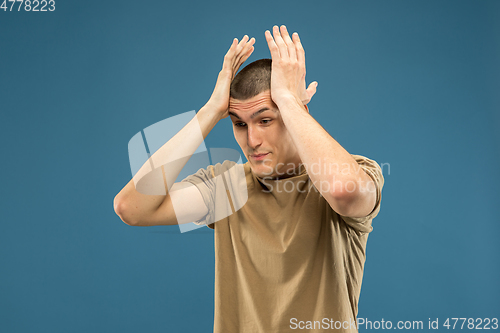 Image of Caucasian young man\'s half-length portrait on blue background