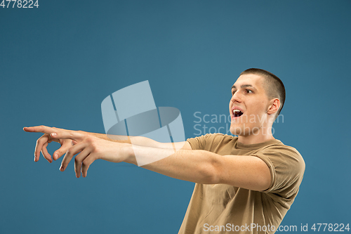 Image of Caucasian young man\'s half-length portrait on blue background