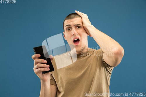 Image of Caucasian young man\'s half-length portrait on blue background
