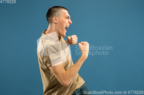 Image of Caucasian young man\'s half-length portrait on blue background