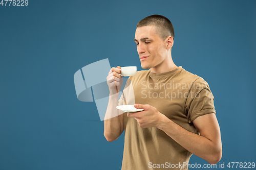Image of Caucasian young man\'s half-length portrait on blue background