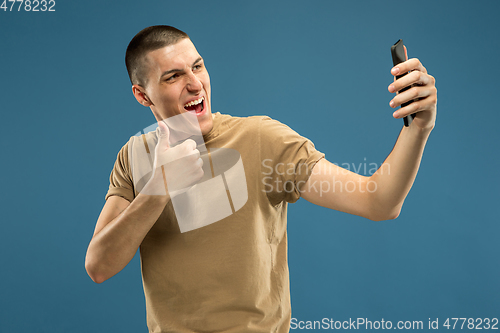Image of Caucasian young man\'s half-length portrait on blue background