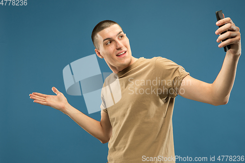 Image of Caucasian young man\'s half-length portrait on blue background