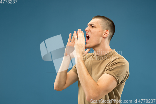 Image of Caucasian young man\'s half-length portrait on blue background