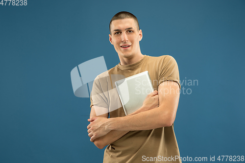 Image of Caucasian young man\'s half-length portrait on blue background
