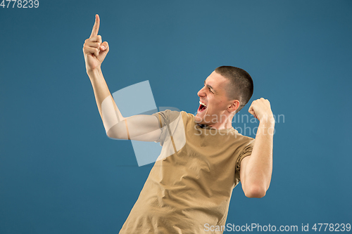 Image of Caucasian young man\'s half-length portrait on blue background