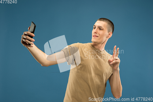 Image of Caucasian young man\'s half-length portrait on blue background