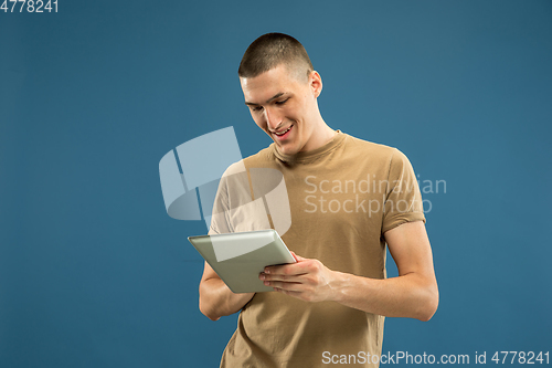 Image of Caucasian young man\'s half-length portrait on blue background