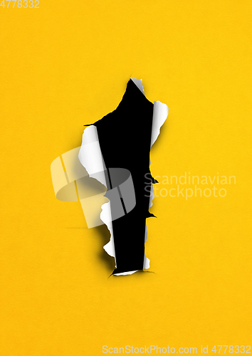 Image of Yellow torn paper with black hole