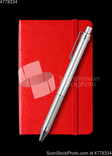 Image of Red closed notebook and pen isolated on black