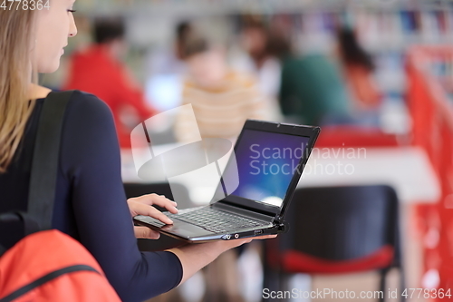 Image of the student uses a notebook and a school library