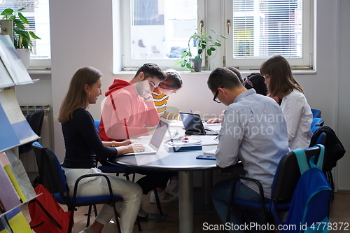 Image of students group working on school project together on tablet computer at modern university