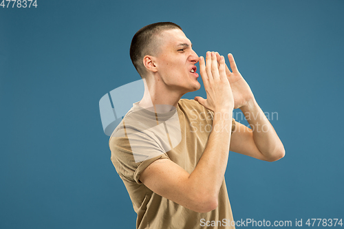 Image of Caucasian young man\'s half-length portrait on blue background