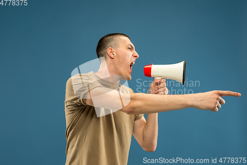 Image of Caucasian young man\'s half-length portrait on blue background
