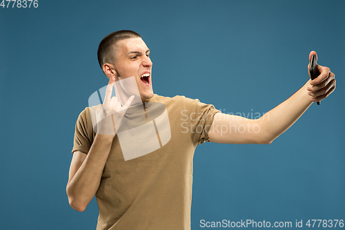 Image of Caucasian young man\'s half-length portrait on blue background