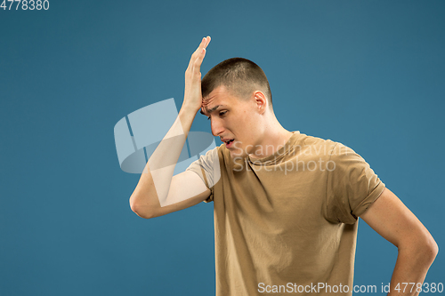 Image of Caucasian young man\'s half-length portrait on blue background