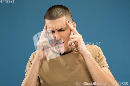 Image of Caucasian young man\'s half-length portrait on blue background
