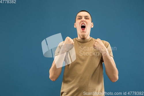 Image of Caucasian young man\'s half-length portrait on blue background