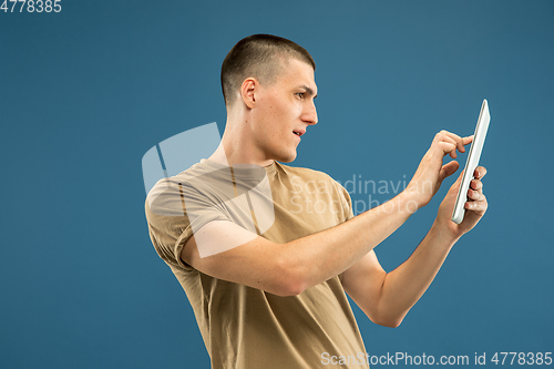 Image of Caucasian young man\'s half-length portrait on blue background