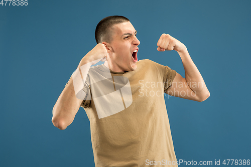 Image of Caucasian young man\'s half-length portrait on blue background