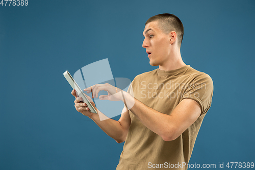 Image of Caucasian young man\'s half-length portrait on blue background