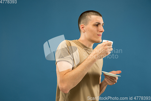 Image of Caucasian young man\'s half-length portrait on blue background
