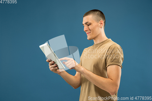 Image of Caucasian young man\'s half-length portrait on blue background