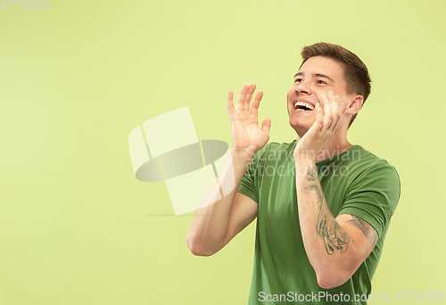 Image of Caucasian young man\'s half-length portrait on green background