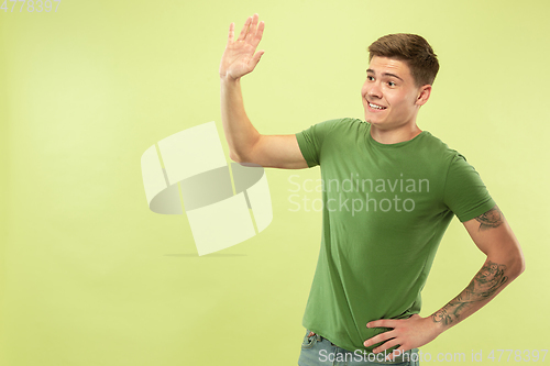 Image of Caucasian young man\'s half-length portrait on green background