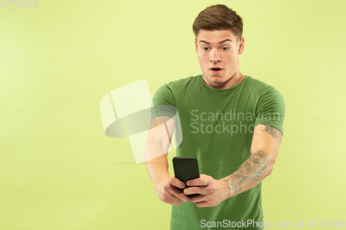 Image of Caucasian young man\'s half-length portrait on green background