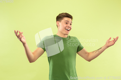 Image of Caucasian young man\'s half-length portrait on green background