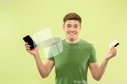 Image of Caucasian young man\'s half-length portrait on green background