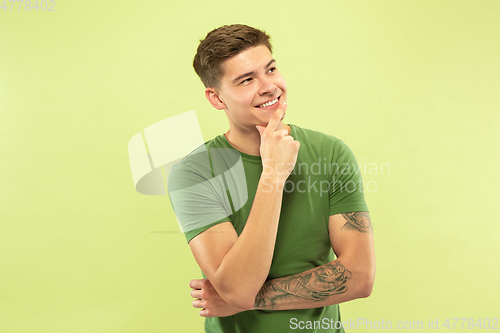 Image of Caucasian young man\'s half-length portrait on green background