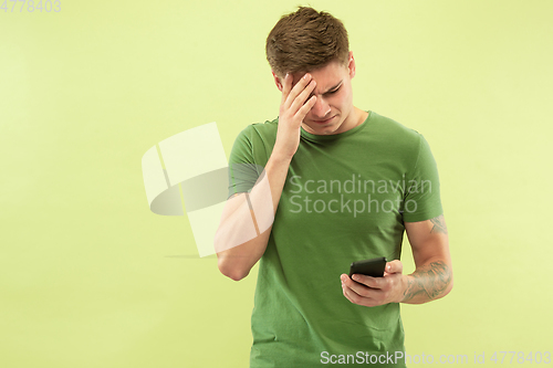 Image of Caucasian young man\'s half-length portrait on green background
