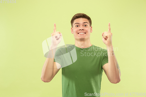Image of Caucasian young man\'s half-length portrait on green background
