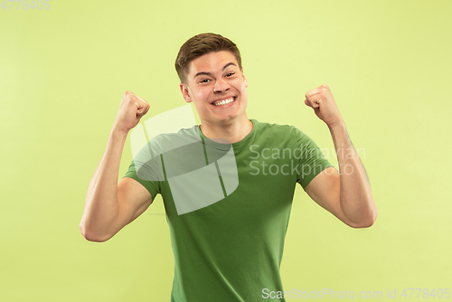 Image of Caucasian young man\'s half-length portrait on green background